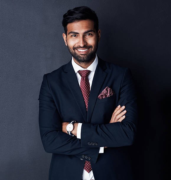 Studio shot of a confident young businessman posing against a gray background